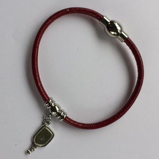 Image d'un bracelet de pickleball en cuir avec pendentif de raquette de pickleball.