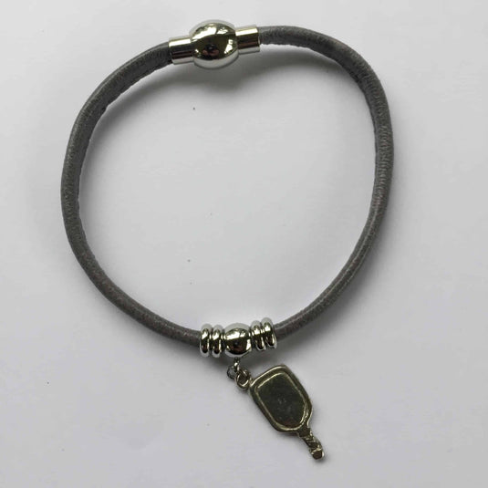 Image d'un bracelet de pickleball en cuir avec pendentif de raquette de pickleball.