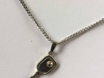 Image d'une chaine de cou ajustable pendentif avec raquette et balle de pickleball.